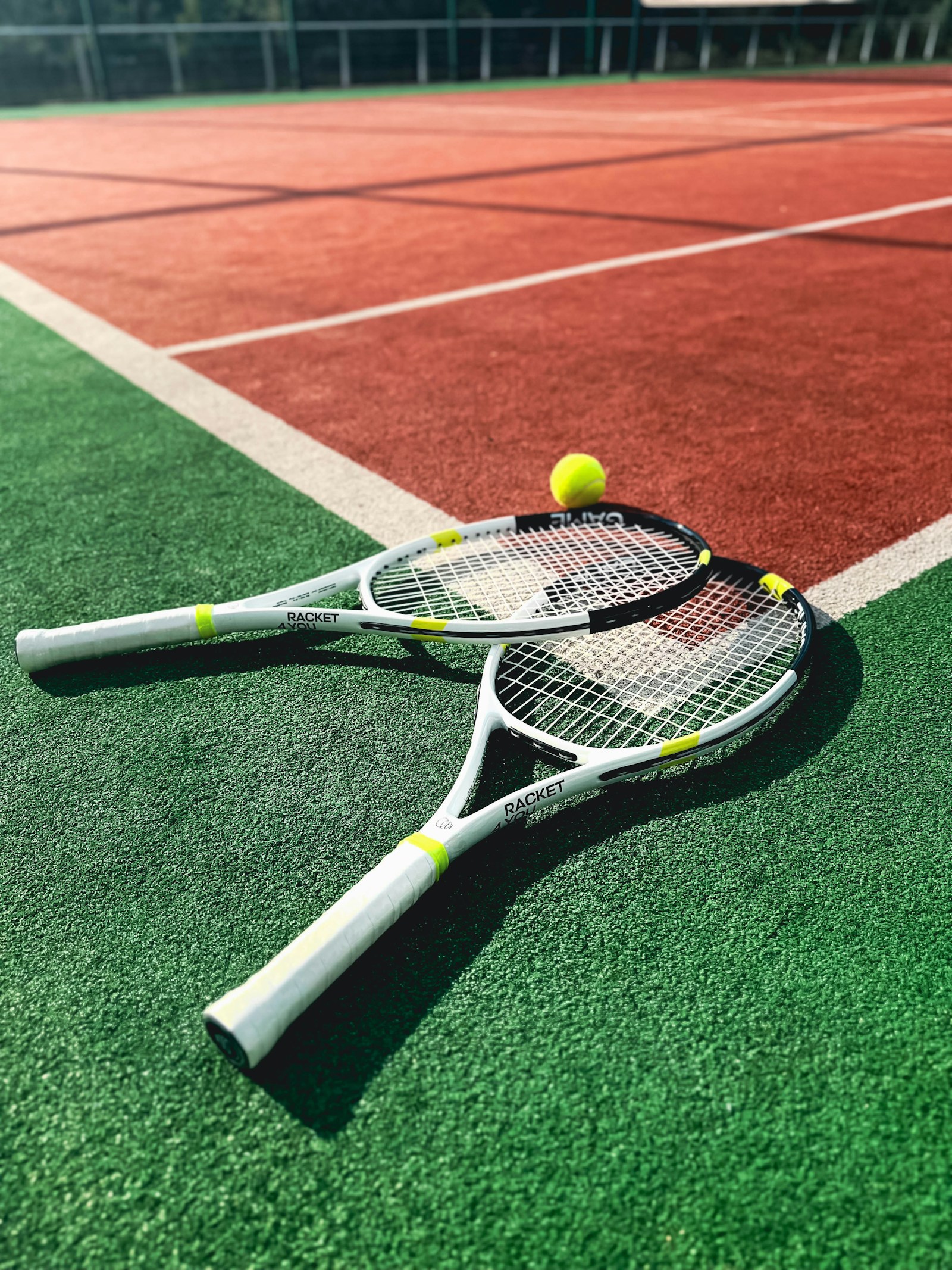 Kortta iki tenis raketi ve bir tenis topu — temsili fotoğraf.